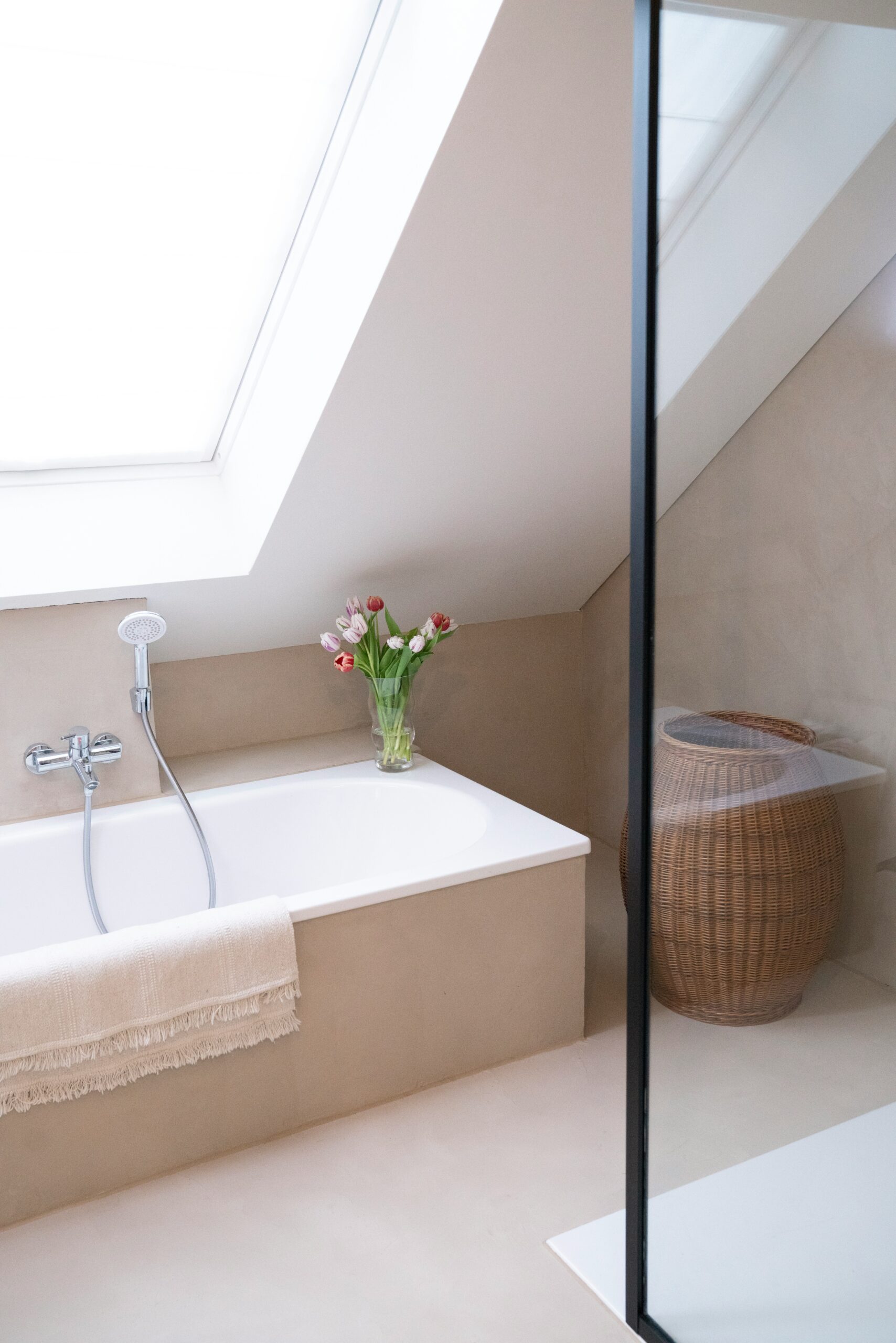 Salle de bains lumineuse avec baignoire sous toiture